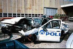Police car totaled in high speed accident with possible negligence of one or more parties.